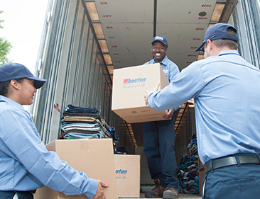 Wheaton movers moving boxes out of a truck.