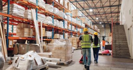 Two workers walk through a warehouse