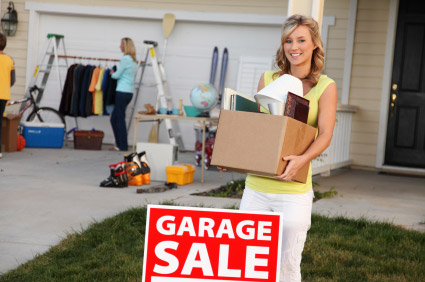 woman holding box of items at a garage sale