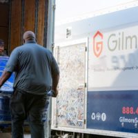 two men moving box into Gilmore moving truck