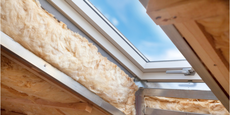 Exposed insulation around a skylight window in an attic