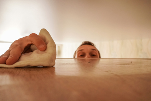 Man dusting a shelf.