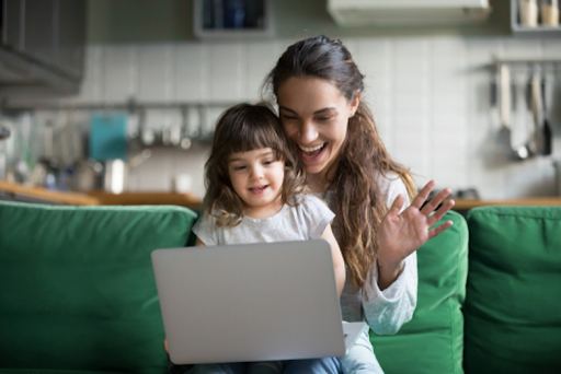 A mom and her child holding a laptop.