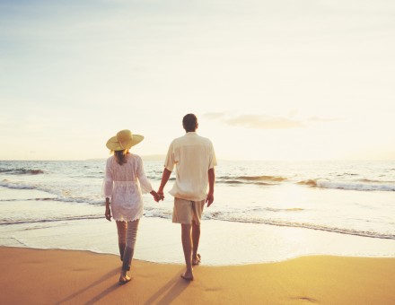 Mature Couple Walking on the Beach at Sunset