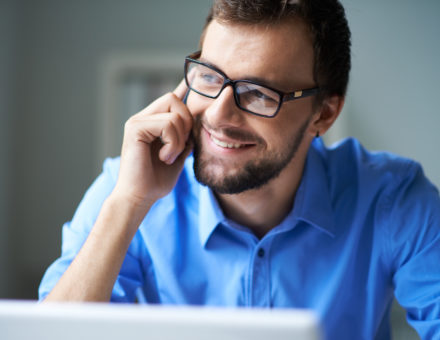 man wearing glasses talking on the cell phone