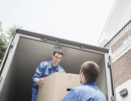 two men loading box out of a moving truck