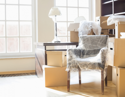 Wrapped up furniture surrounded by moving boxes