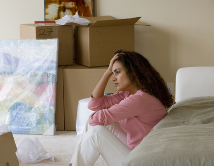women sitting in packed up bedroom