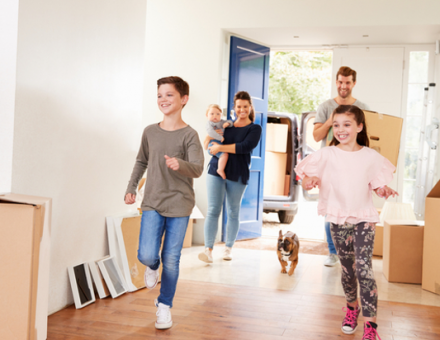 Kids running into new home with cardboard boxes