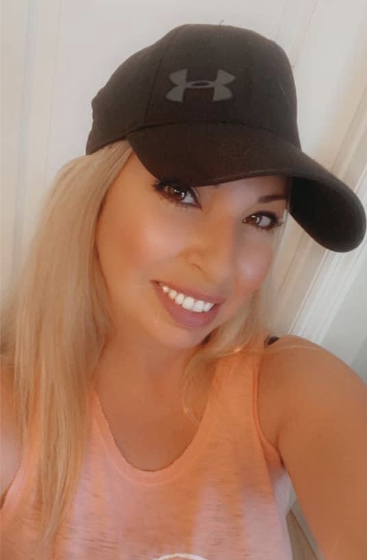 selfie of a woman in a black Underarmour hat
