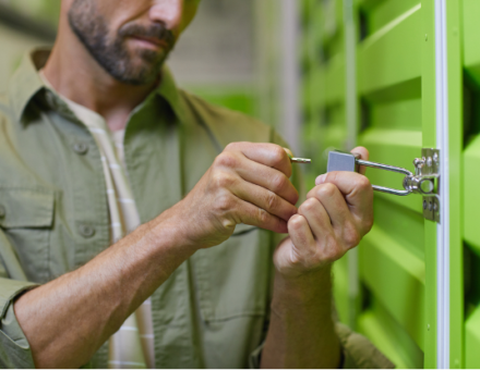 man inserting key into storage unit lock