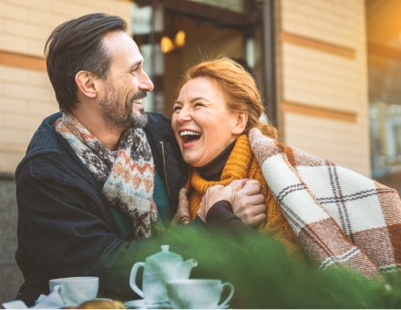 Middle aged couple laughing together at a cafe