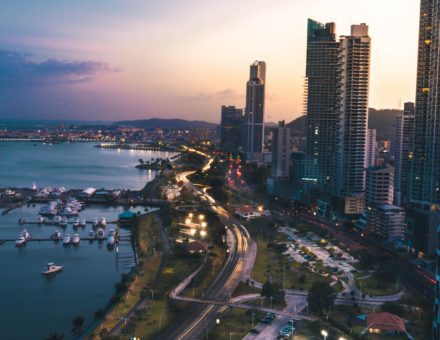 A city and its surrounding body of water at sunset.