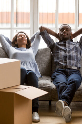 Couple relaxing next to boxes.