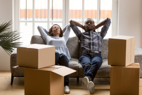 Couple relaxing next to boxes.