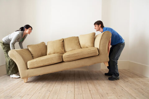 couple moving a couch.