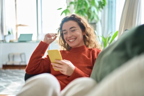 Woman sitting on couch and smiling.