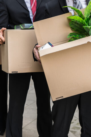 People in office attire moving boxes.