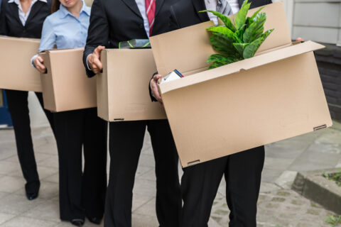 People in office attire moving boxes.