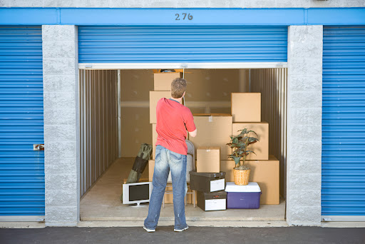 Person closing a storage door with their belongings inside.