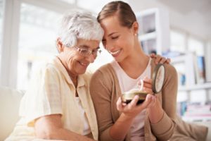 Mother and daughter hugging and holding an item.