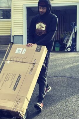 Person rolling a bookshelf on a moving dolly.