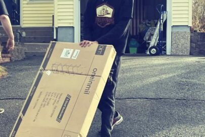 Person rolling a bookshelf on a moving dolly.