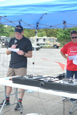 man with microphone at Wheaton Pulls for Good event