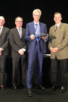 Group of people in suits holding an award.