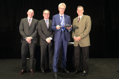 Group of people in suits holding an award.