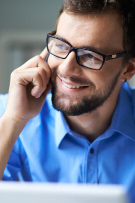 man wearing glasses talking on the cell phone