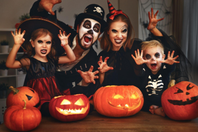 Family celebrating Halloween with costumes and pumpkins