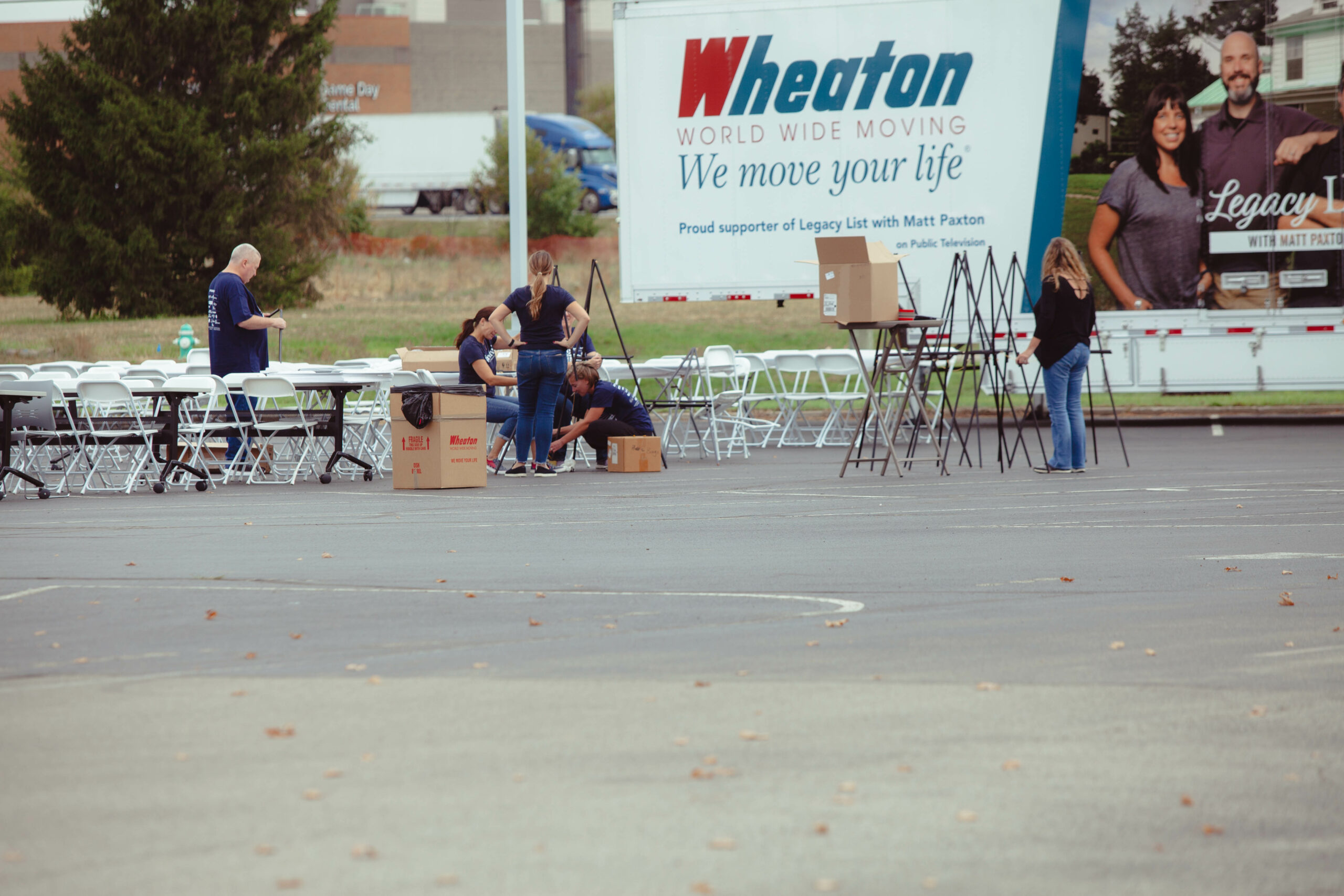 Volunteers, staff and sponsors set up tables and chairs for the Indy Truck Pull