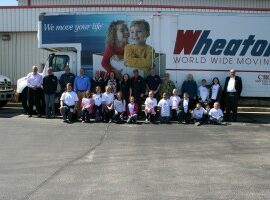 people posing in front of Wheaton's moving truck