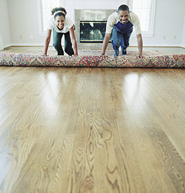 couple rolling out a rug in their new home