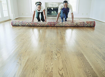 couple rolling out a rug in their new home