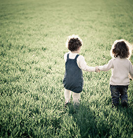 two kids playing in the grass