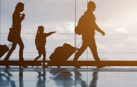 family pulling suitcases through airport