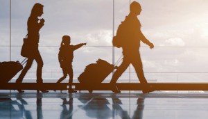 family pulling suitcases through airport