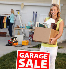 woman holding box of items at a garage sale