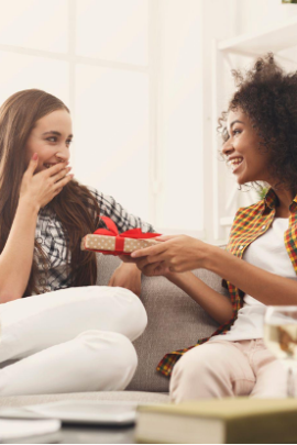 Excited woman getting a gift from her friend.