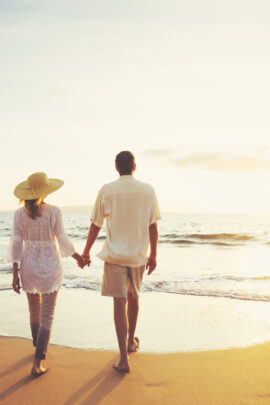 Mature Couple Walking on the Beach at Sunset