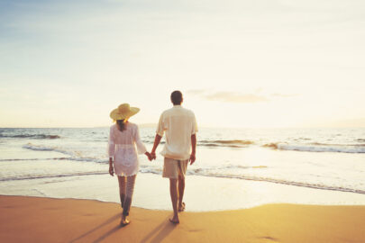 Mature Couple Walking on the Beach at Sunset