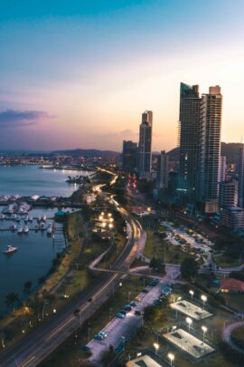 A city and its surrounding body of water at sunset.