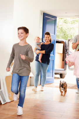 Kids running into new home with cardboard boxes