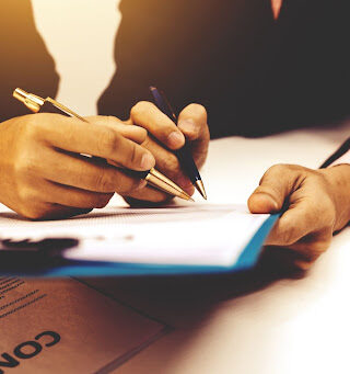 Two hands holding pens and a clipboard.