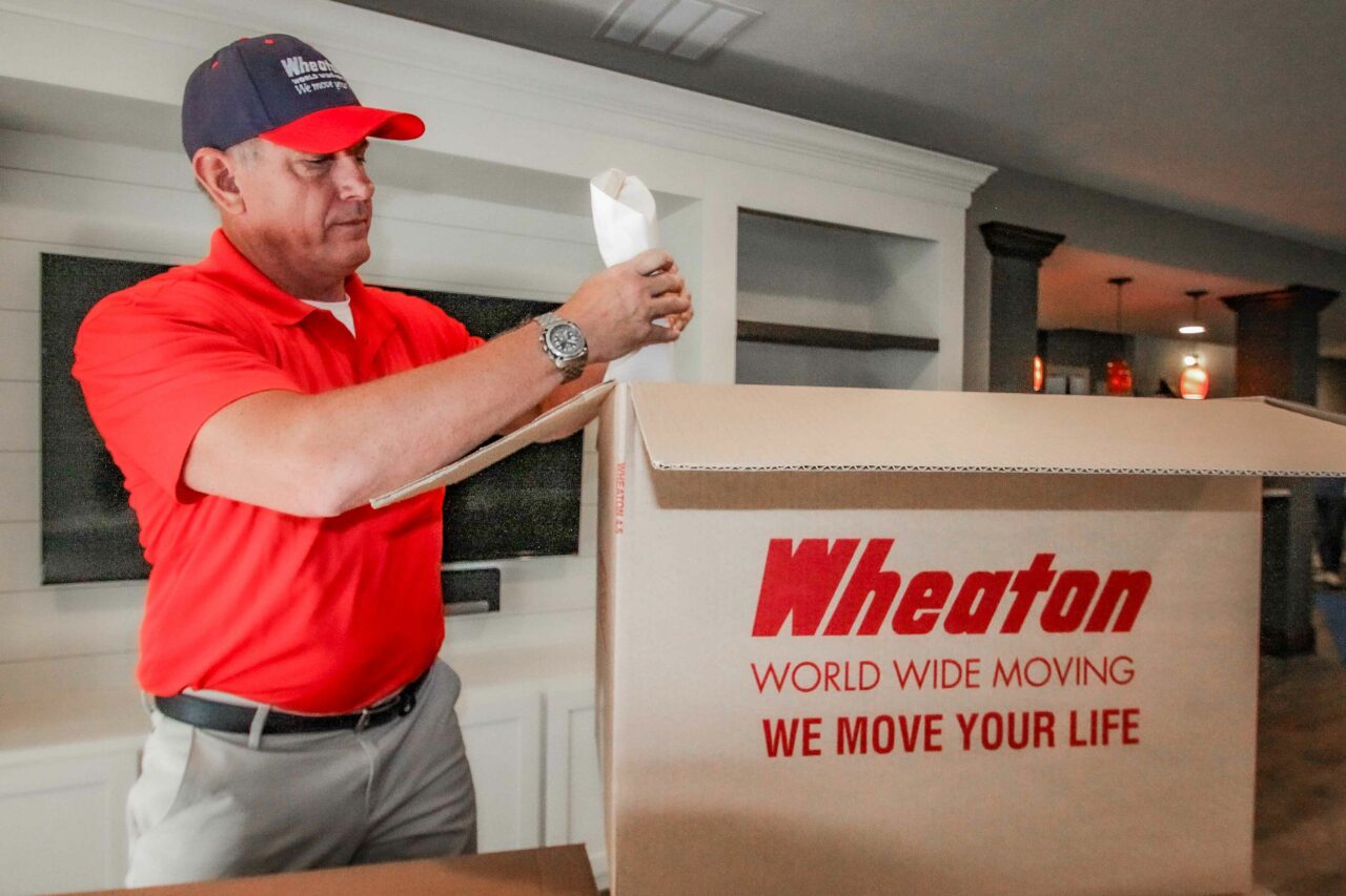 Wheaton mover packing a box.