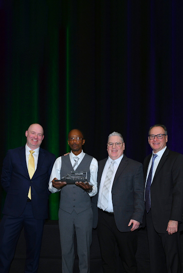 4 people holding an award.