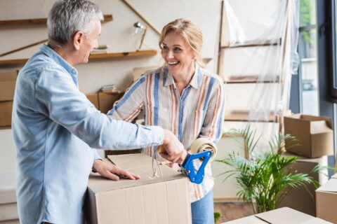 elderly couple packing up moving boxes