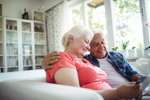 An elderly couple on the couch.